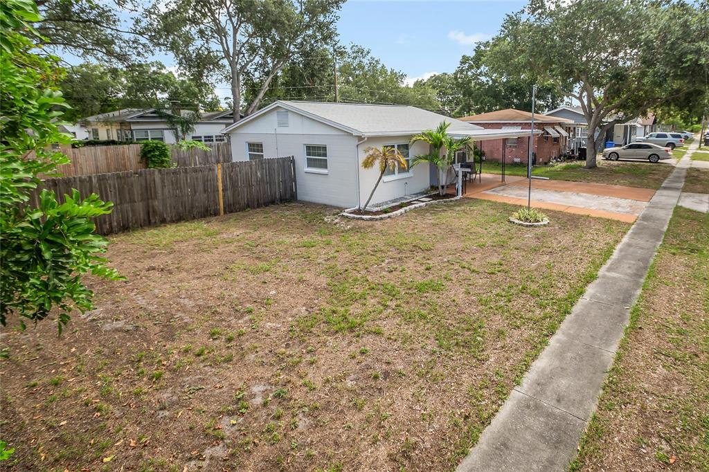 A single-story house with a white exterior, a side carport, and a fenced yard — 2151 44TH AVENUE N, ST PETERSBURG, FL