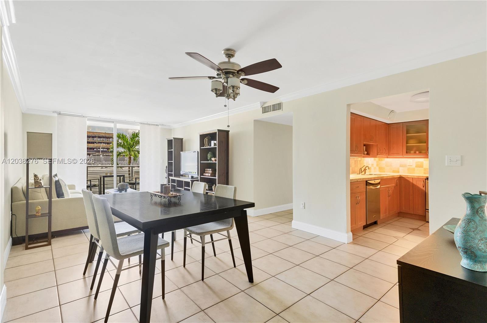 A dining area with a dark table and chairs sits adjacent to a kitchen — 1605 Bay Rd # 308, Miami Beach FL 33139, MIAMI BEACH, FL