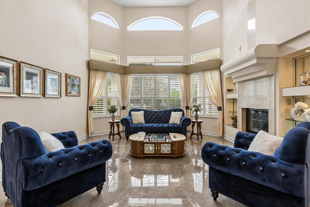 A living room features blue tufted furniture, a fireplace, and large windows with arched tops — 1036 GOLF VALLEY DRIVE, APOPKA, FL