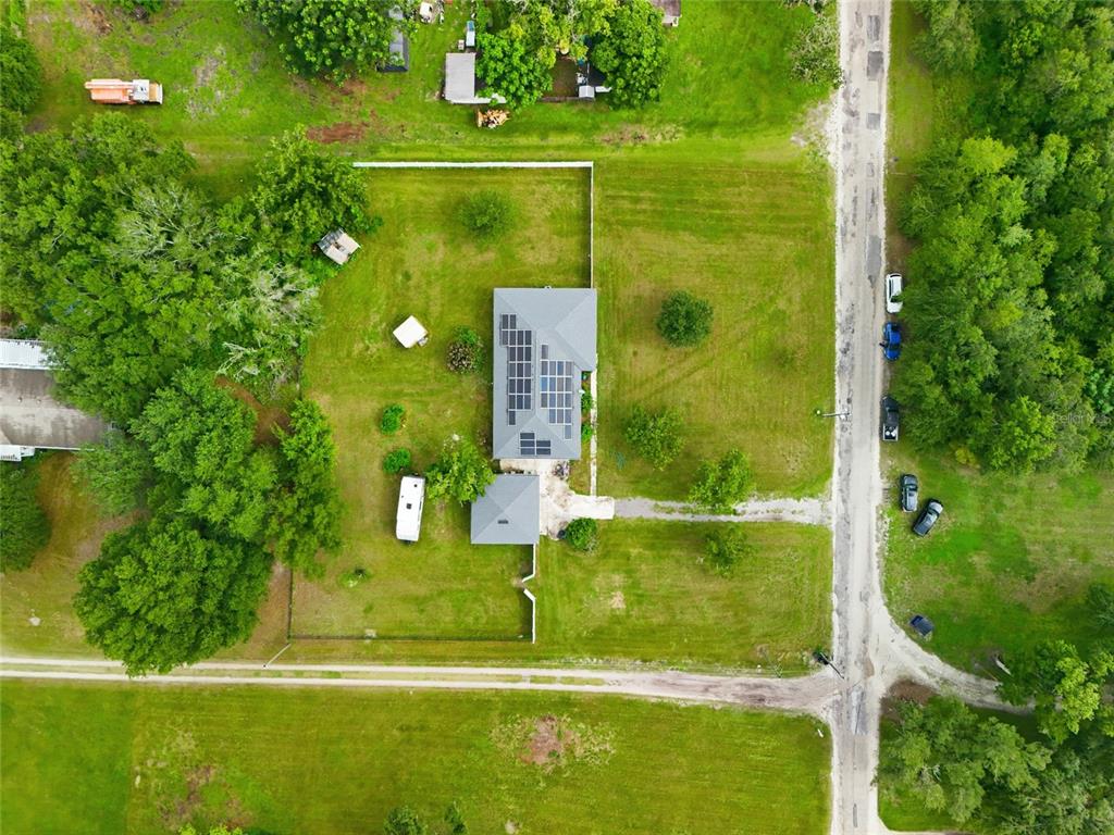 An aerial view shows a house with solar panels on a large, grassy rural lot — 4741 SEABERG ROAD, ZEPHYRHILLS, FL