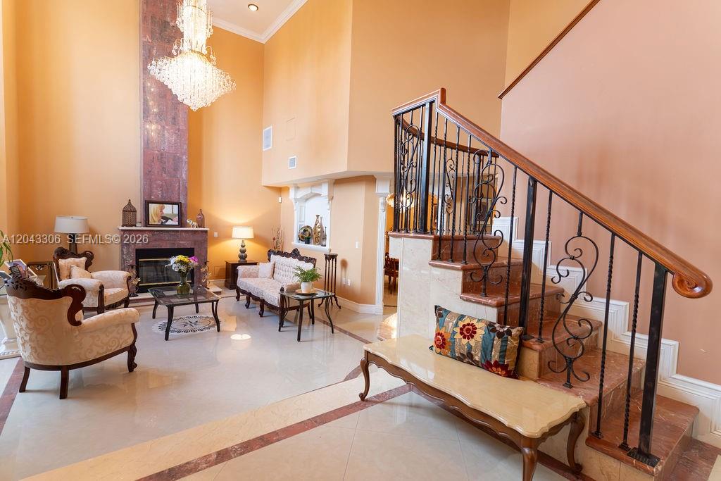 A living room features a high ceiling, a crystal chandelier, a fireplace, and a staircase — 13370 SW 34th St, Miami FL 33175, MIAMI, FL
