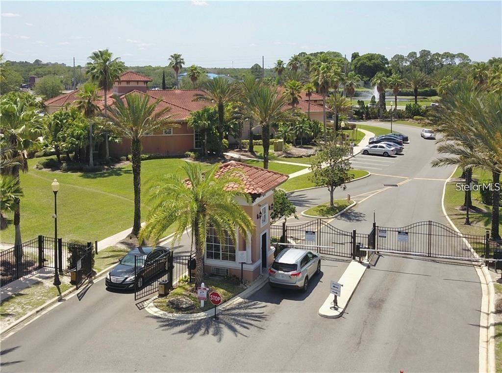 An aerial view shows a gated community entrance with a guardhouse and parked cars — 5554 METROWEST BOULEVARD UNIT 4-201, ORLANDO, FL