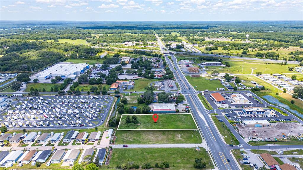 An aerial view shows a vacant rectangular lot marked with a red pin near a highway — 1919 W C 48, BUSHNELL, FL