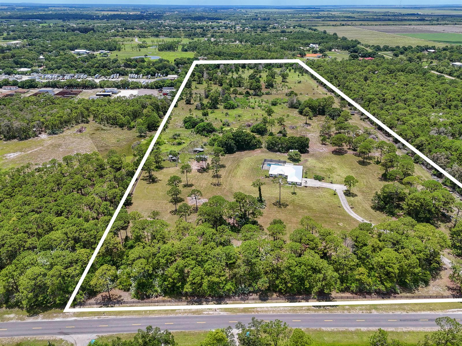 An aerial view shows a house with a pool on a large, partially wooded lot — 425 N Ffa Road, Fort Pierce FL 34945, FORT PIERCE, FL