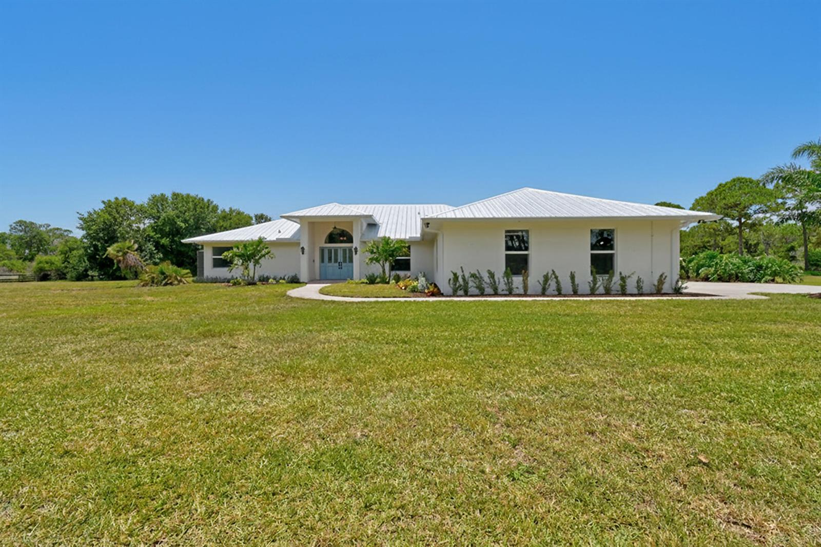A single-story house with a white metal roof and light blue front doors — 425 N Ffa Road, Fort Pierce FL 34945, FORT PIERCE, FL