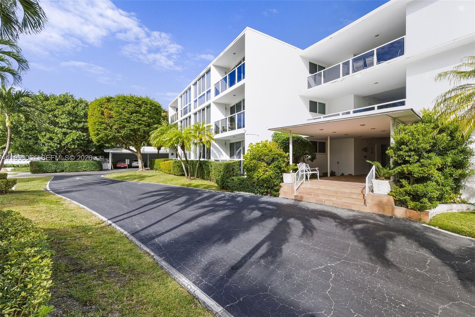A three-story white apartment building features a paved driveway and a covered entrance — 1 Harbour Way # 108, Bal Harbour FL 33154, BAL HARBOUR, FL
