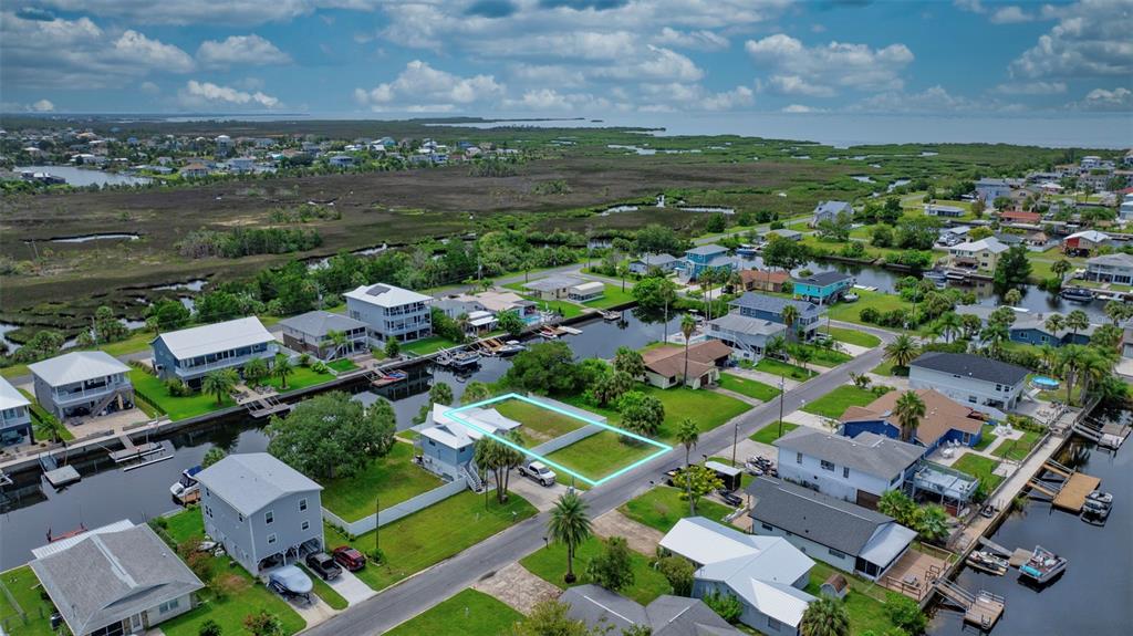 An aerial view shows a vacant residential lot outlined in blue within a coastal neighborhood — CENTAVO COURT, HERNANDO BEACH, FL