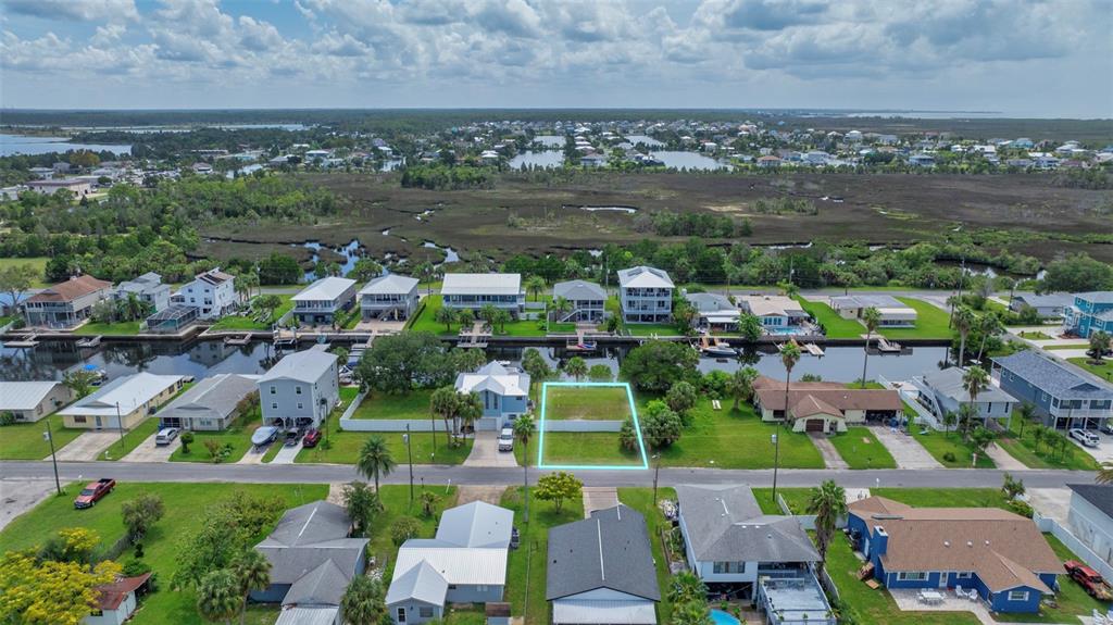 An aerial view shows a vacant residential lot outlined in blue along a canal — CENTAVO COURT, HERNANDO BEACH, FL