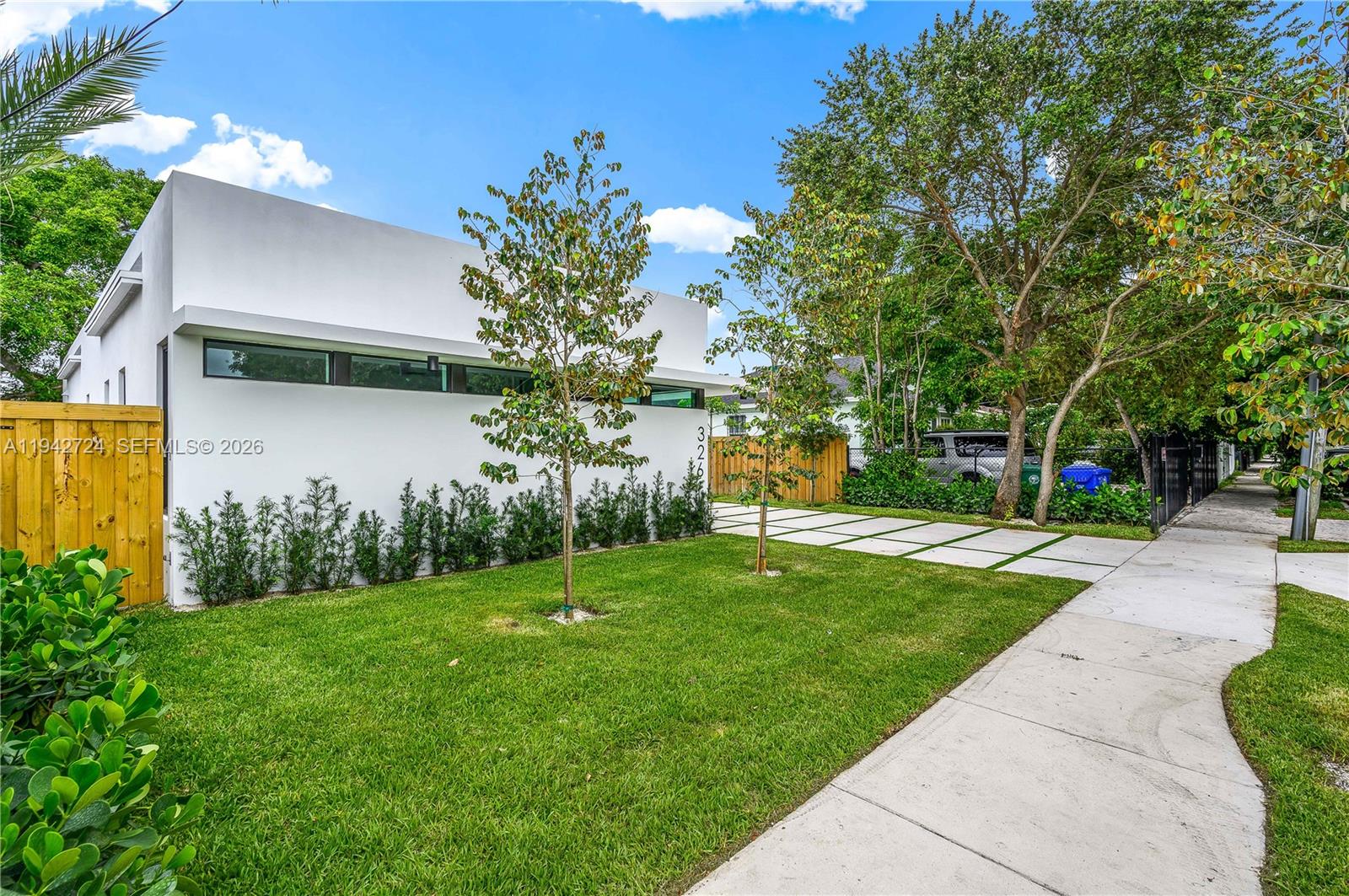 A modern white house with a flat roof features a grass lawn and driveway — 326 NW 40th St, Miami FL 33127, MIAMI, FL