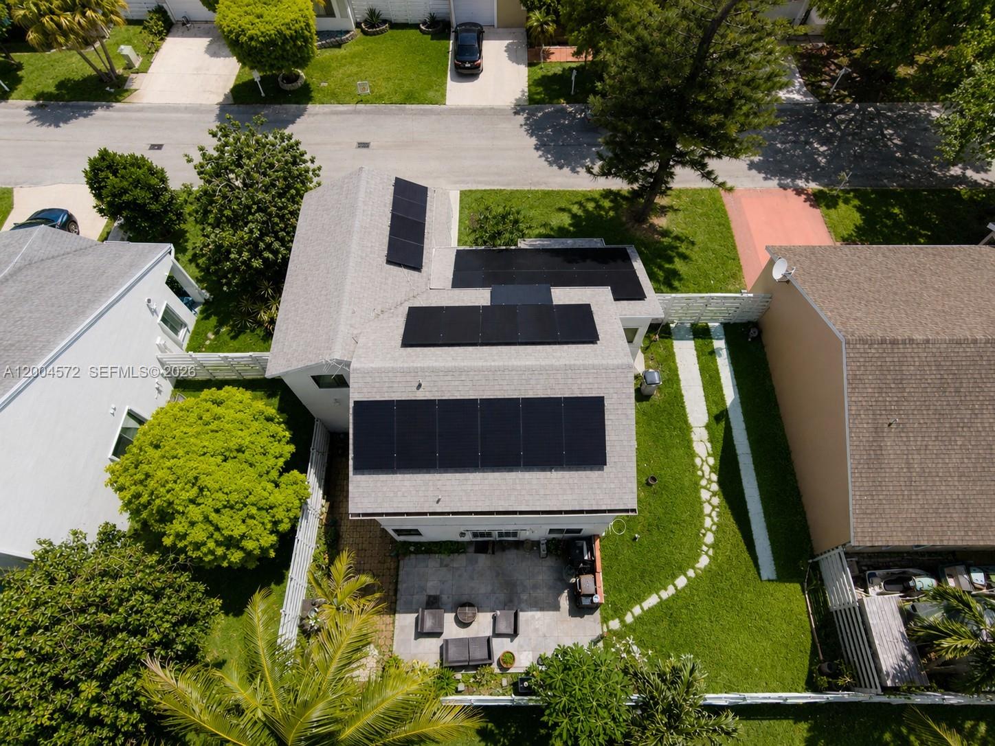 An aerial view shows a house with solar panels on the roof and a backyard patio — 14512 SW 139th Ave Cir W, Miami FL 33186, MIAMI, FL
