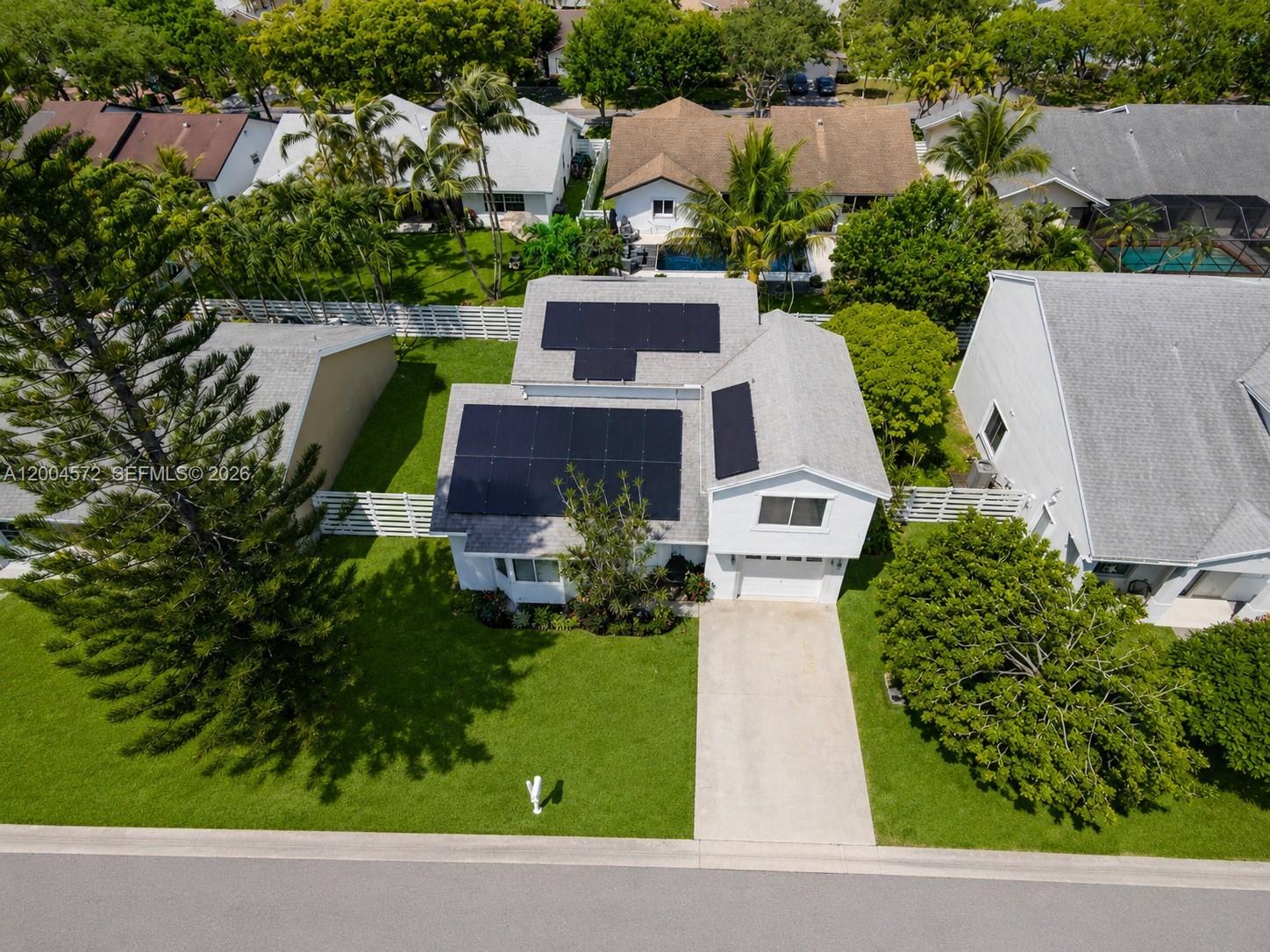 An aerial view shows a house with solar panels on the roof and a driveway — 14512 SW 139th Ave Cir W, Miami FL 33186, MIAMI, FL