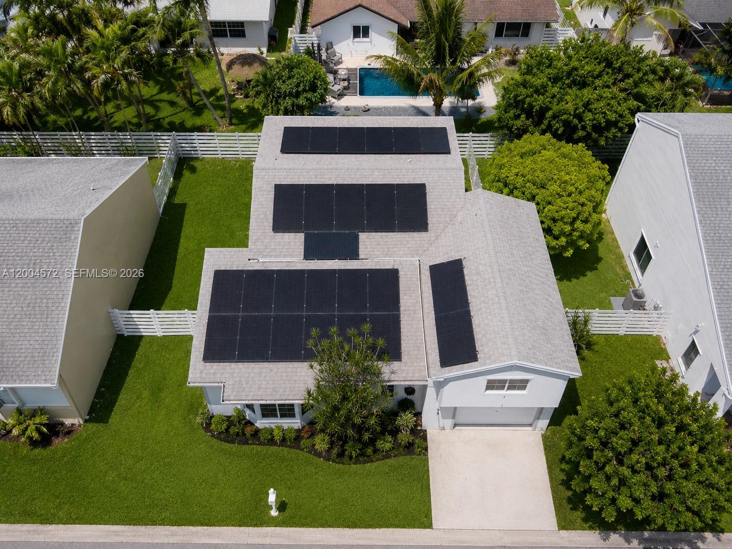 An aerial view shows a house with solar panels on the roof and a front lawn — 14512 SW 139th Ave Cir W, Miami FL 33186, MIAMI, FL