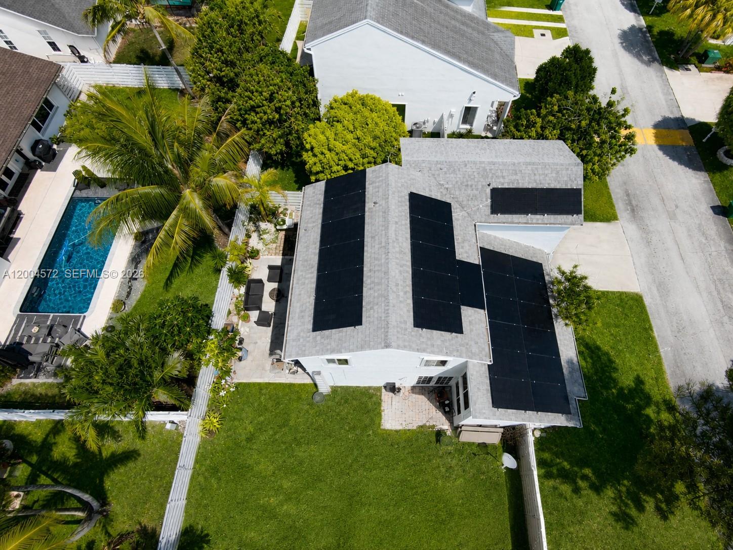 An aerial view shows a house with solar panels on the roof and a pool — 14512 SW 139th Ave Cir W, Miami FL 33186, MIAMI, FL