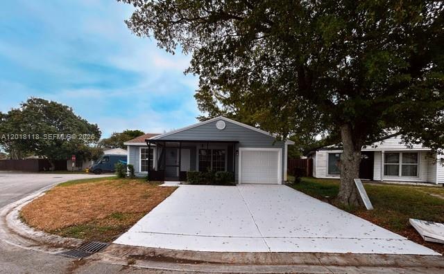 A single-story house with a white garage door, a screened porch, and a large tree — 1792 SW 84th Ave, Miramar FL 33027, MIRAMAR, FL