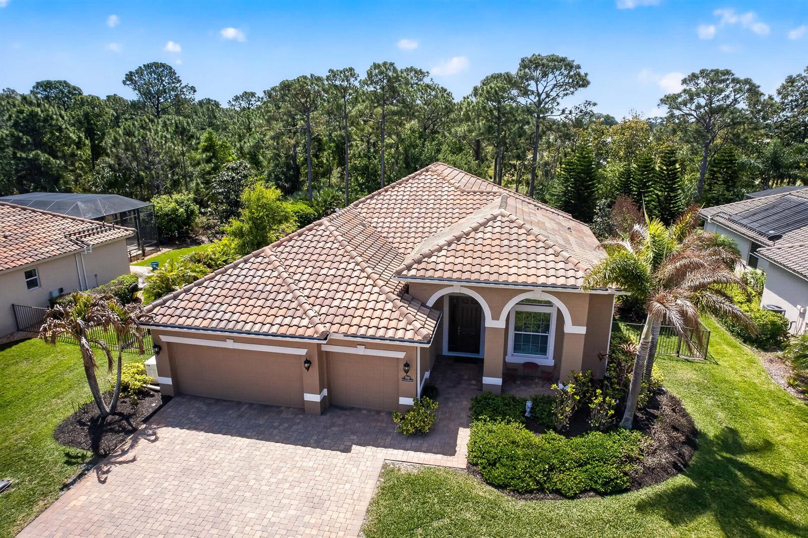 An aerial view of a tan single-story house with a tiled roof and paver driveway — 7589 Fieldstone Ranch Square, Vero Beach FL 32967, VERO BEACH, FL