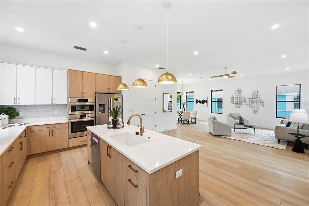 A modern open-concept kitchen with light wood cabinets, white countertops, and an island — 6325 11TH AVENUE S, GULFPORT, FL