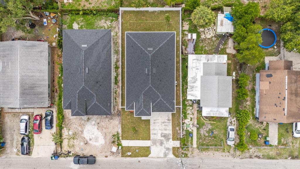 An aerial view shows two adjacent houses with dark shingled roofs and surrounding residential lots — 8210 N ELMER STREET, TAMPA, FL