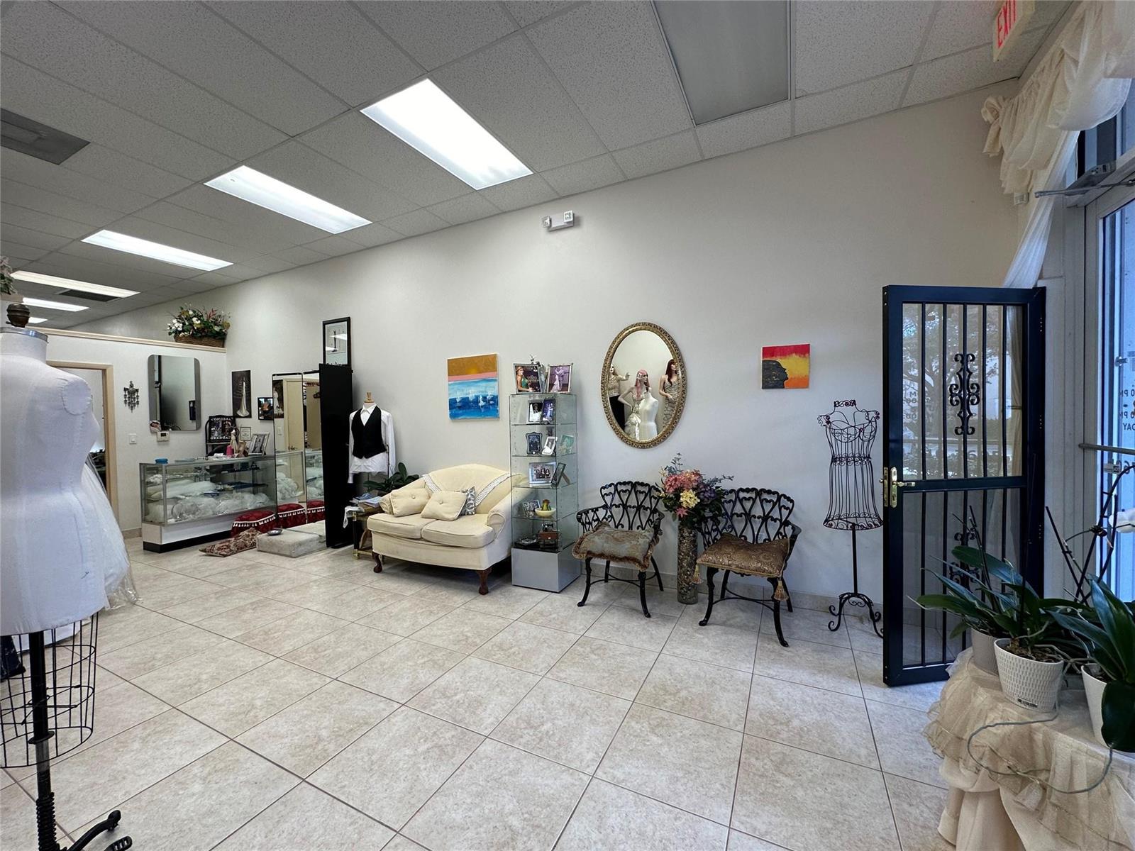 A retail space features tile flooring, a seating area, display cases, and a glass door — CORAL SPRINGS, FL