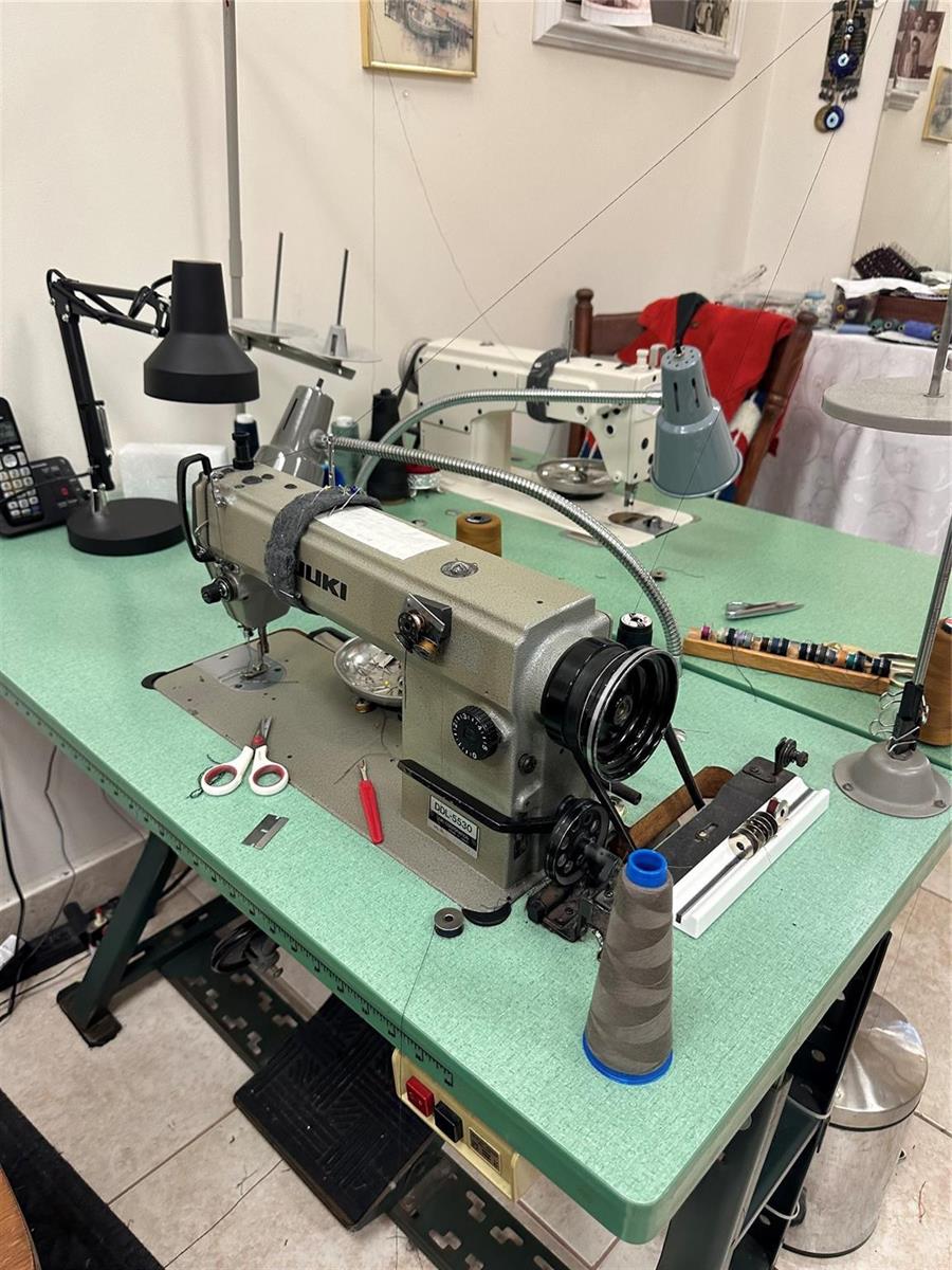 A sewing room features a Juki industrial sewing machine on a green work table — CORAL SPRINGS, FL