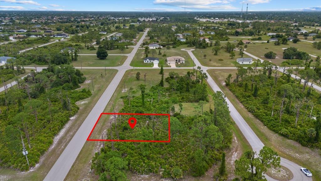 An aerial view shows a vacant, wooded residential lot outlined in red along a paved road — 49 MASTHEAD ROAD, PLACIDA, FL