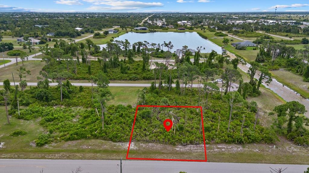 An aerial view shows a vacant, wooded residential lot outlined in red along a road — 49 MASTHEAD ROAD, PLACIDA, FL