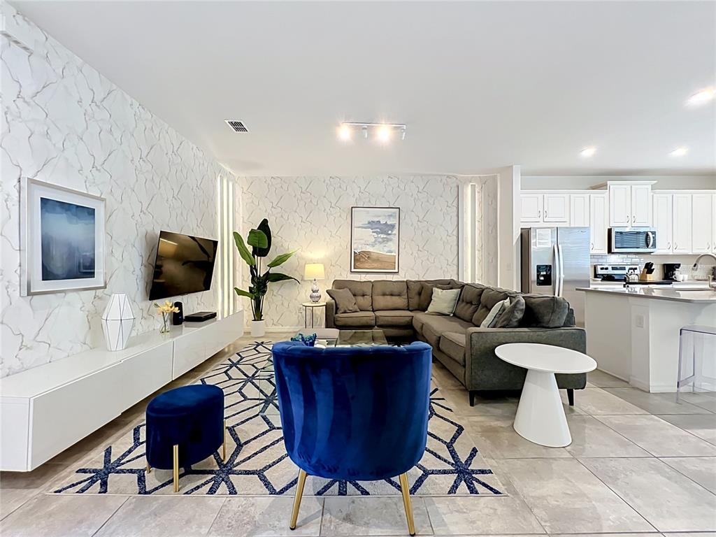 A living room features marble-patterned wallpaper, a grey sectional sofa, and a blue velvet chair — 8976 AMELIA DOWNS TRAIL, KISSIMMEE, FL
