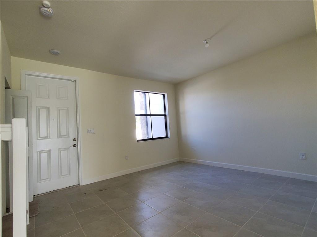 An empty room features light-colored walls, tile flooring, a white door, and a single window — 3216 W 114th Terrace, Hialeah FL 33018, HIALEAH, FL