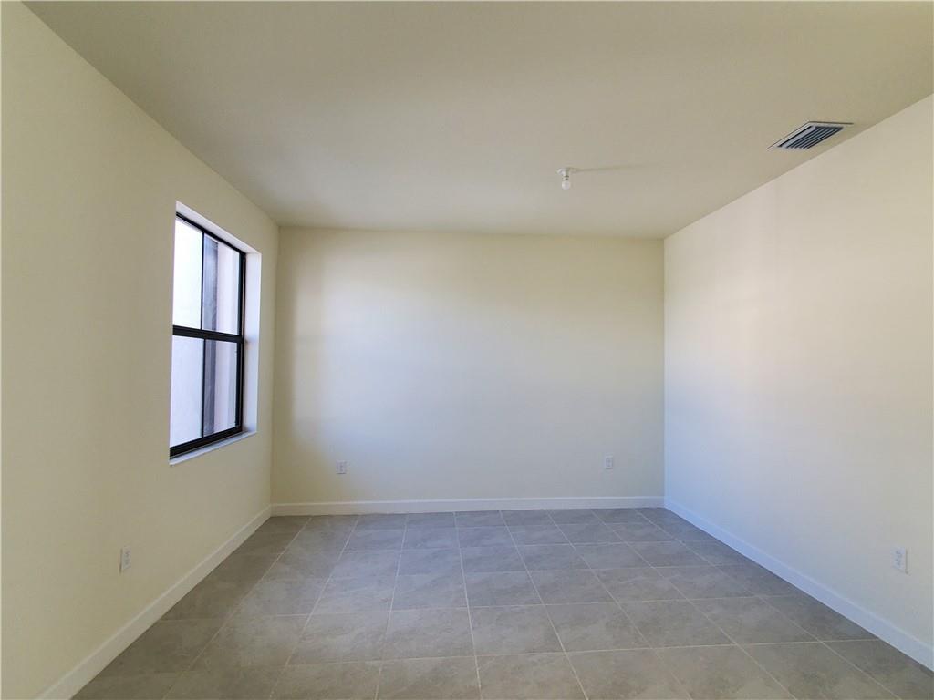 An empty room features light-colored walls, gray tile flooring, and a single window — 3216 W 114th Terrace, Hialeah FL 33018, HIALEAH, FL