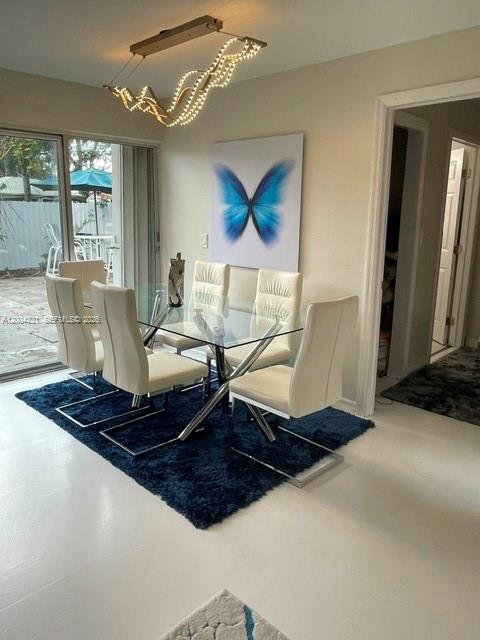 A dining room features a glass table, white chairs, a blue rug, and butterfly wall art — 3219 Buckley Ave, Lake Worth FL 33461, LAKE WORTH, FL