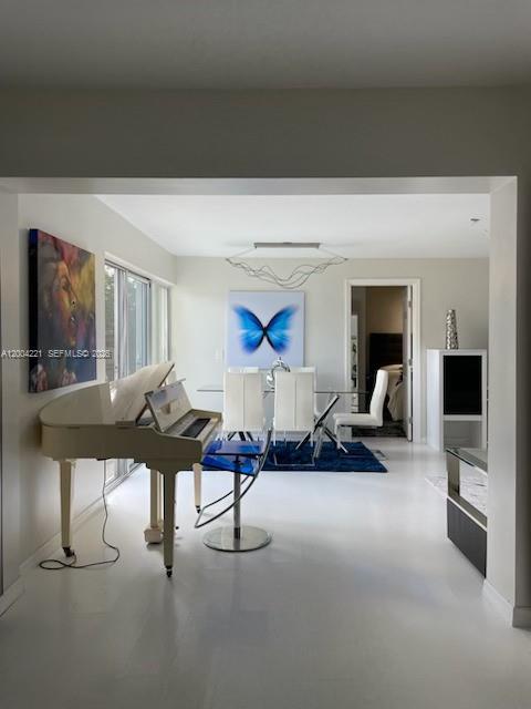 A white grand piano sits in a bright living area with a dining set beyond — 3219 Buckley Ave, Lake Worth FL 33461, LAKE WORTH, FL