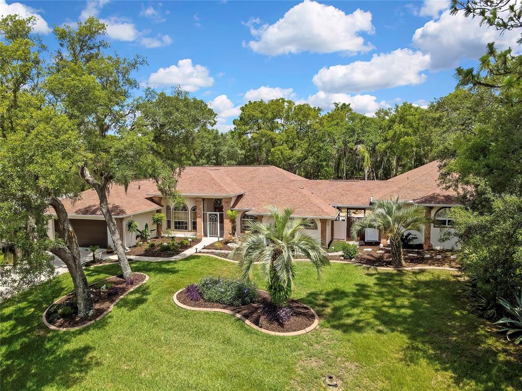 An aerial view of a single-story house with a brown roof and landscaped front yard — 5701 W CHIVE LOOP, HOMOSASSA, FL