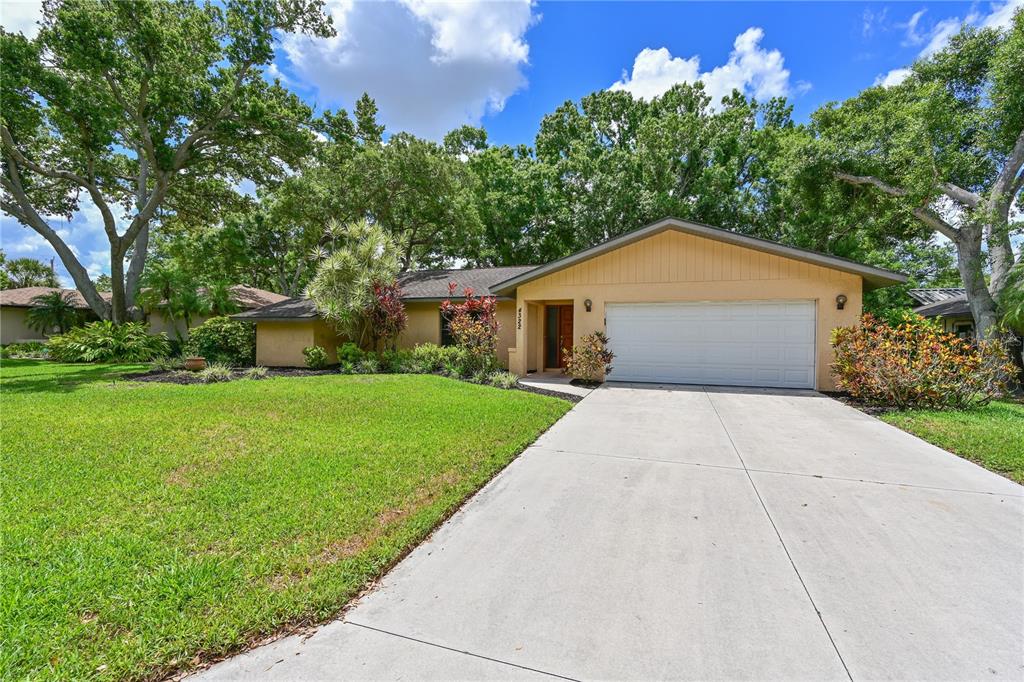 A single-story house with a tan exterior, a two-car garage, and a concrete driveway — 4322 PASADENA COURT, SARASOTA, FL