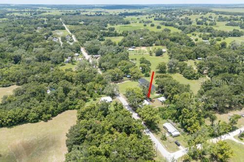 An aerial view shows a rural property with a house, outbuildings, and surrounding wooded land — 37315 TRILBY ROAD, DADE CITY, FL