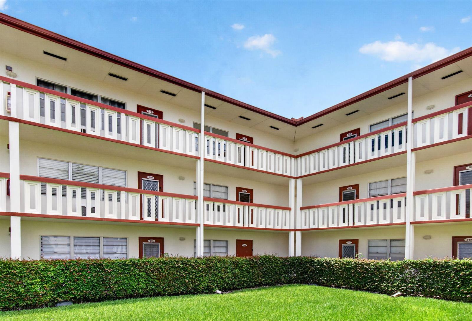 A three-story apartment building with exterior walkways and balconies overlooks a manicured lawn — 374 Brighton I # 374, Boca Raton FL 33434, BOCA RATON, FL