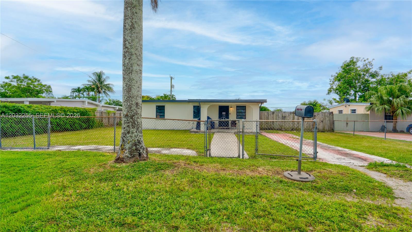 A single-story house with a chain-link fence and a mailbox in the front yard — 9840 SW 48th St, Miami FL 33165, MIAMI, FL