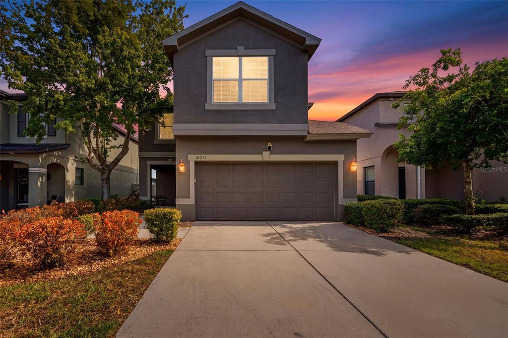 A two-story house with a gray exterior, a two-car garage, and a concrete driveway — 10257 NEWMINSTER LOOP, RUSKIN, FL