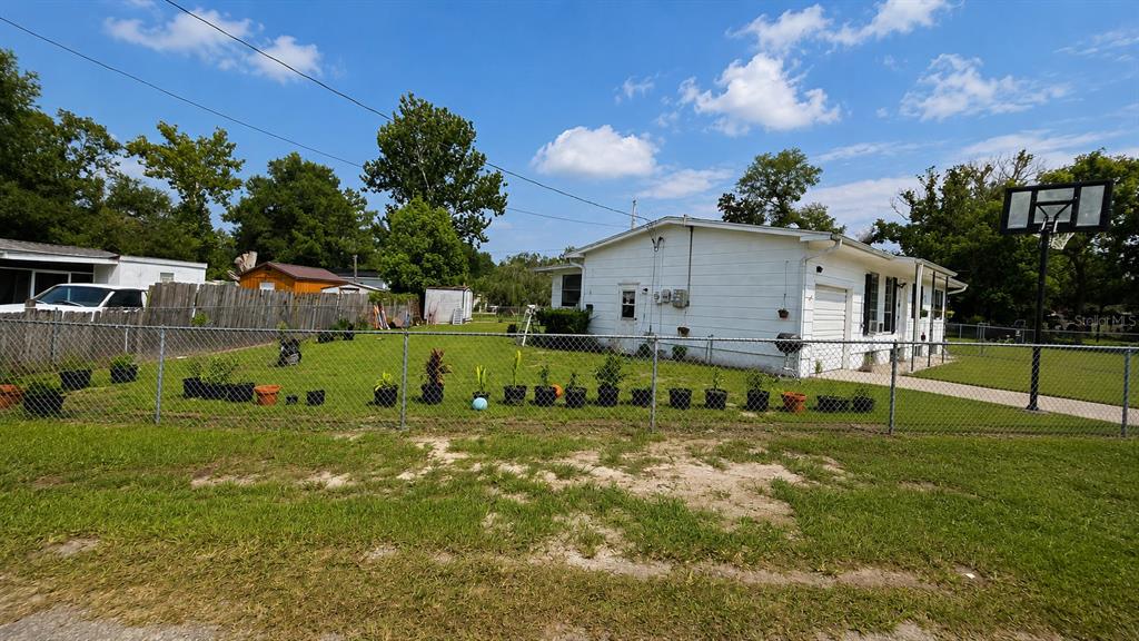 A white, single-story house with a fenced yard and a basketball hoop in the back — 354 PARK DRIVE, DELAND, FL