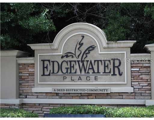 A stone and stucco monument sign for Edgewater Place stands in front of green trees — 8532 EDGEWATER PLACE BOULEVARD, TAMPA, FL