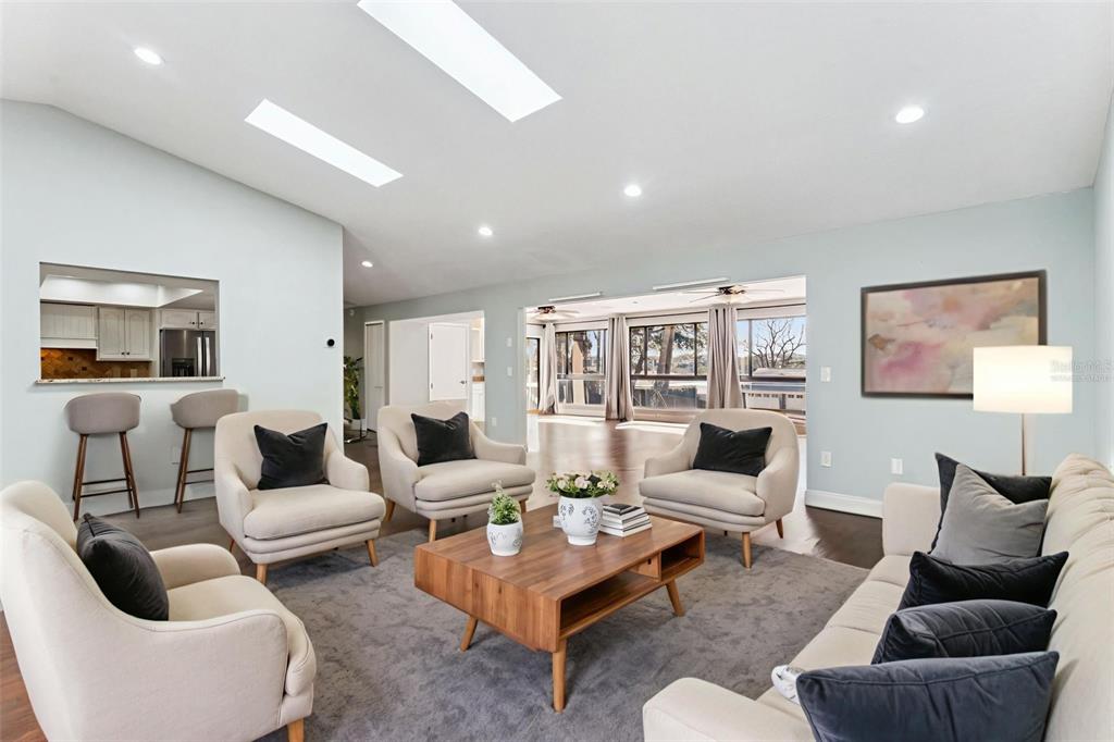A living room with light-colored furniture, a wooden coffee table, and skylights in the ceiling — 448 STONEWOOD LANE, MAITLAND, FL