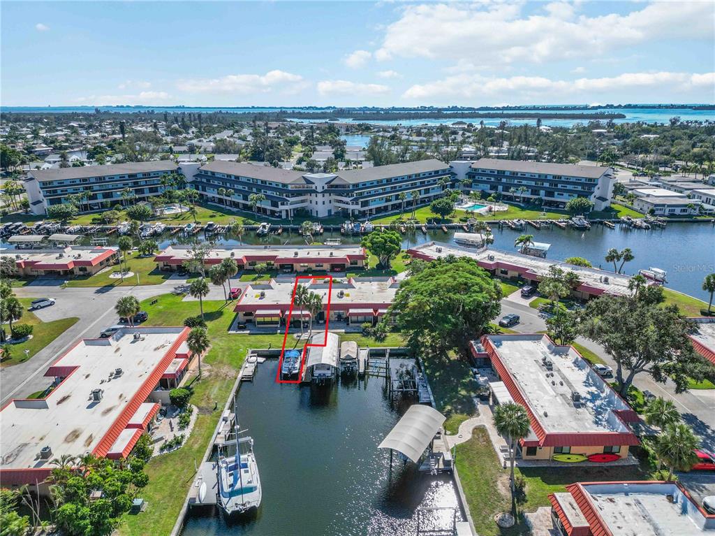 An aerial view shows a waterfront condominium complex with a boat slip highlighted in red — 9608 VALENCIA COVE, BRADENTON, FL