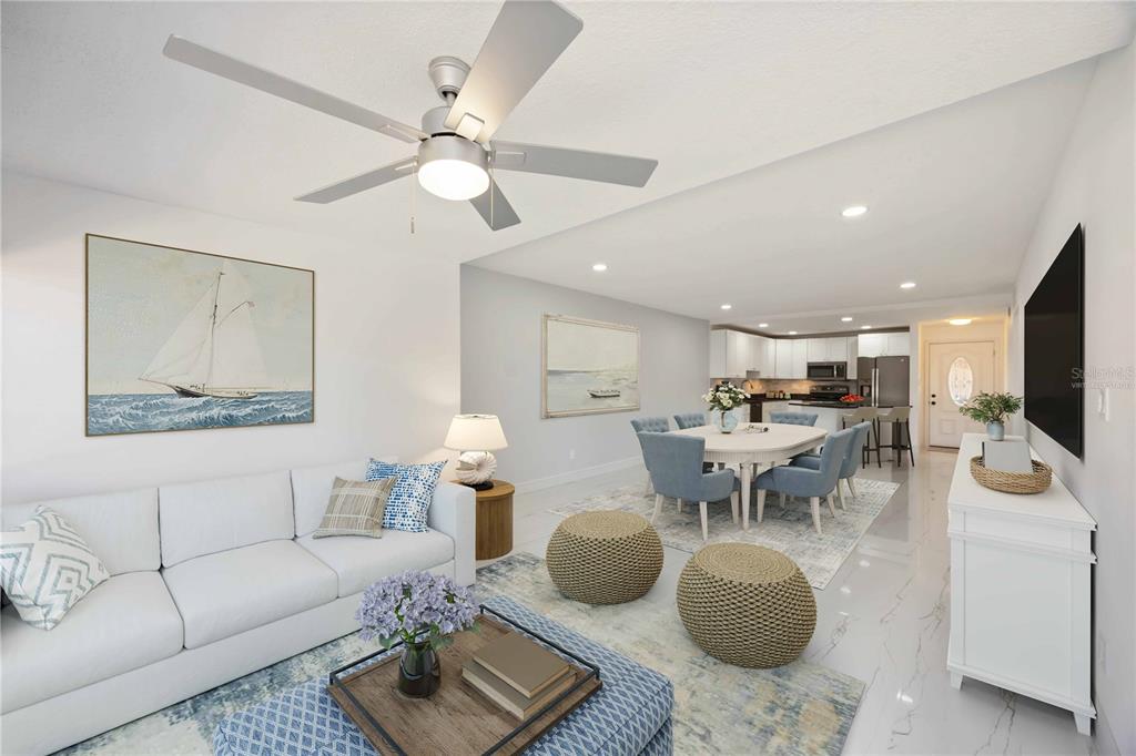 A bright, open-concept living and dining area features white tile floors and a ceiling fan — 9608 VALENCIA COVE, BRADENTON, FL