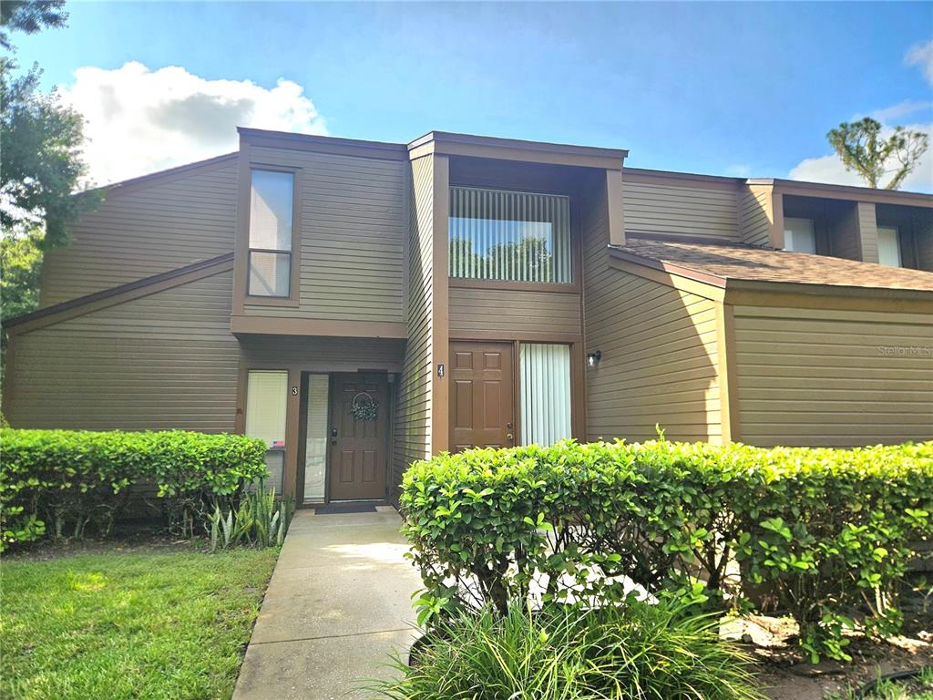 A two-story brown townhouse exterior features two front doors and a concrete walkway — 4 SHERBURY COURT UNIT 4, PALM COAST, FL