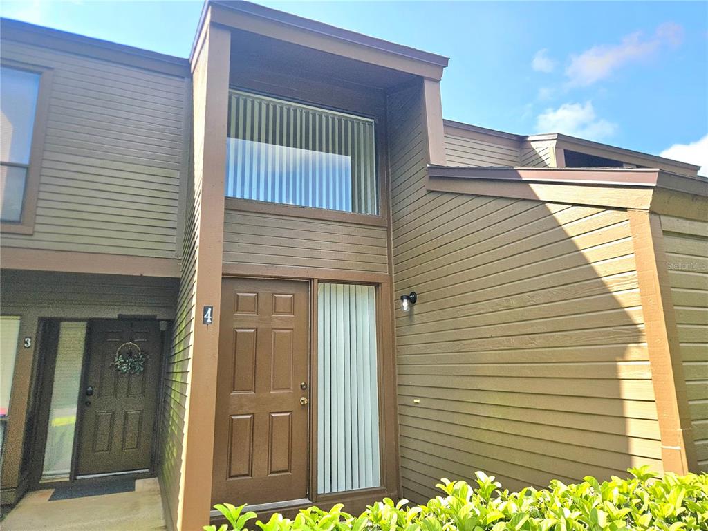 The exterior of a brown townhouse features a front door labeled number four — 4 SHERBURY COURT UNIT 4, PALM COAST, FL