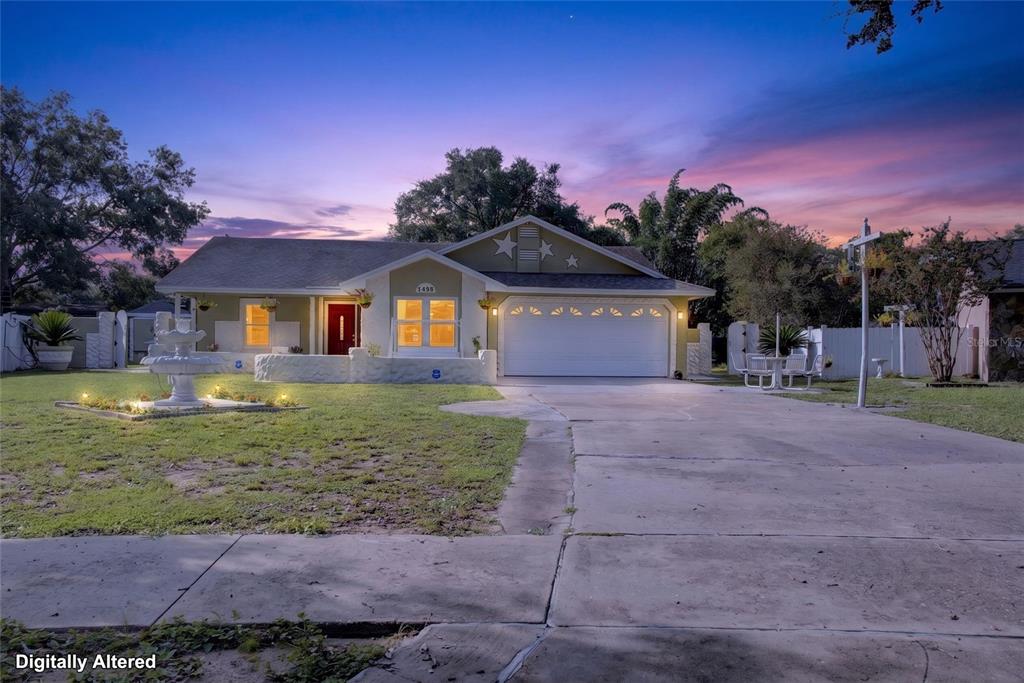 A single-story house with a white garage, a red front door, and a front lawn fountain — 1435 LAMPLIGHTER WAY, ORLANDO, FL