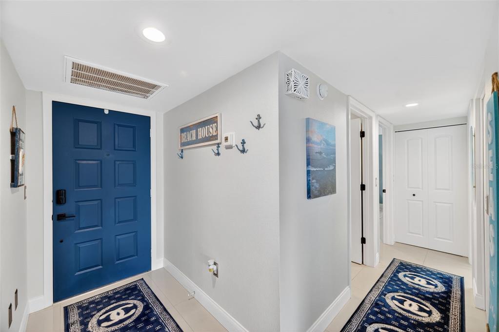 An entryway features a blue door, light gray walls, and two blue patterned rugs — 700 STARKEY ROAD UNIT 352, LARGO, FL