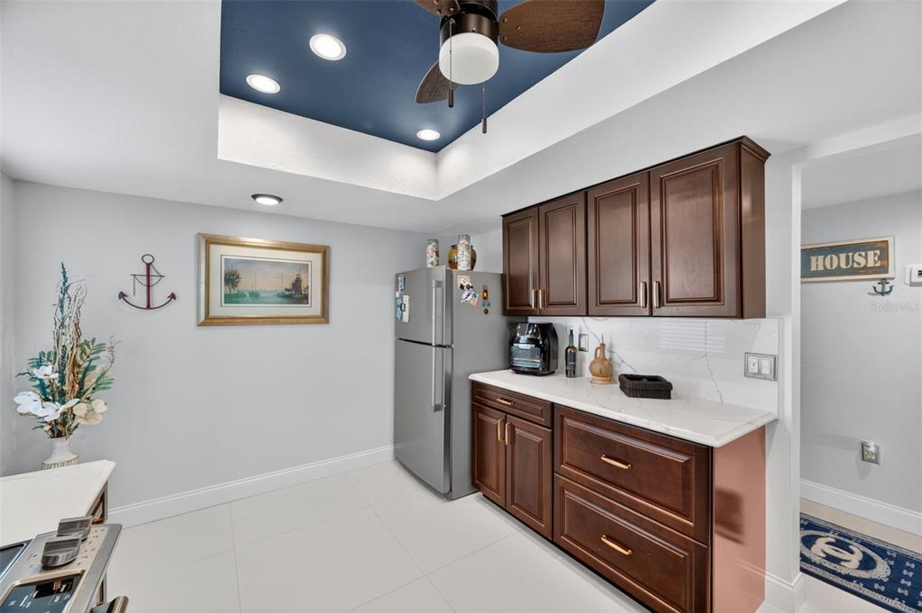 A kitchen area features dark wood cabinets, a stainless steel refrigerator, and a blue ceiling — 700 STARKEY ROAD UNIT 352, LARGO, FL