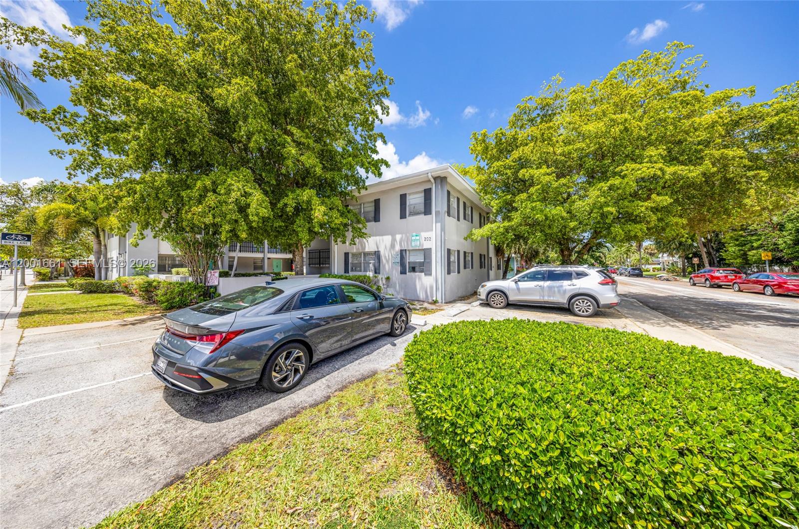 A two-story apartment building with a gray car parked in front on a sunny day — 202 Lucerne Ave # 14, Lake Worth FL 33460, LAKE WORTH, FL
