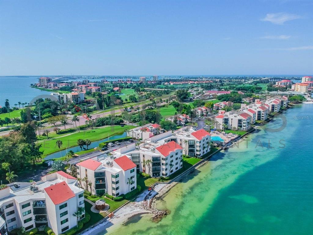 An aerial view of waterfront condominium buildings situated along a coastline next to a golf course — 5505 PUERTA DEL SOL BOULEVARD S UNIT 325, ST PETERSBURG, FL