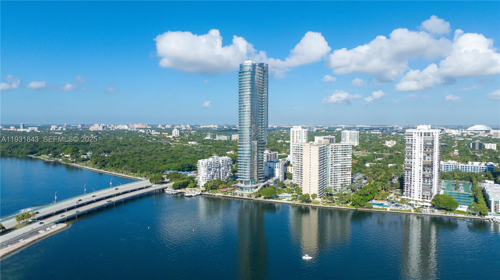 An aerial view shows a tall glass skyscraper surrounded by other buildings and a bridge — 175 SE 25th Rd # 4201, Miami FL 33129, MIAMI, FL