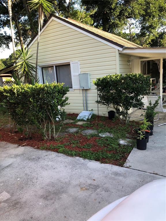 Exterior view of a light yellow house with a concrete driveway and landscaped yard — 5226 BRAFORD ROAD, APOPKA, FL